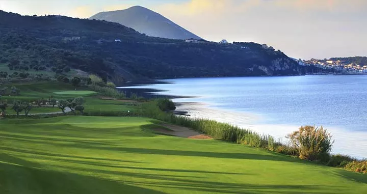 golfplatz direkt am meer mit bergen im hintergrund