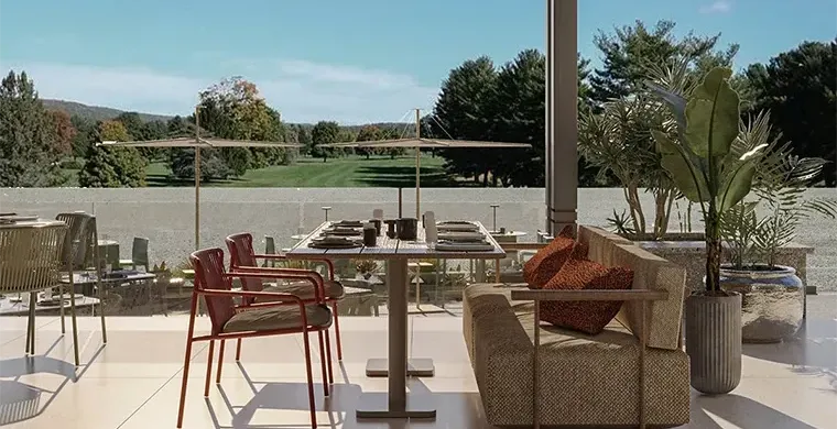 Crowne-Plaza-West-Cairo-Arkan Ein moderner Essbereich im Freien mit einem Tisch für vier Personen, roten Stühlen, einer gepolsterten Bank, Topfpflanzen und Sonnenschirmen – ideal zum Entspannen nach einer Golfrundreise durch Irland – bietet einen Blick auf einen grünen Rasen und Bäume unter strahlend blauem Himmel.